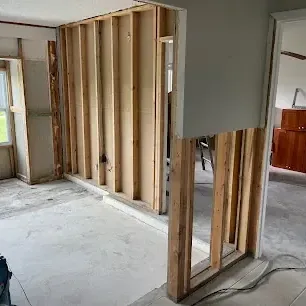 Wet drywall cut away above the flood line in a home with the wall studs exposed