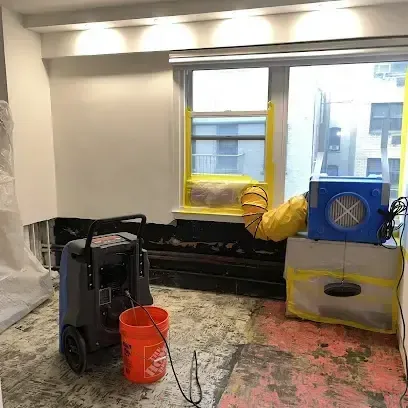 Dehumidifier and air mover drying out a room after the flooring was pulled