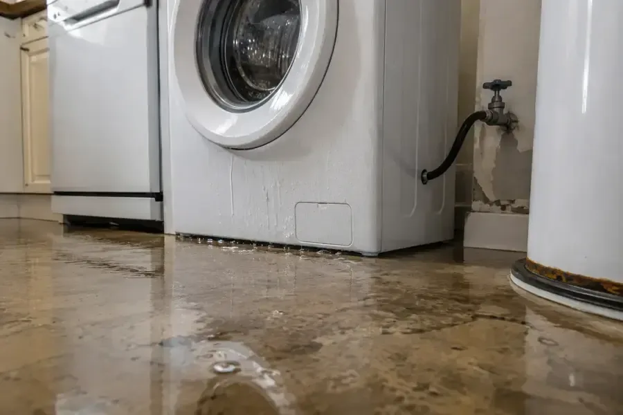 Washing machine leak spreading water across a laundry room floor